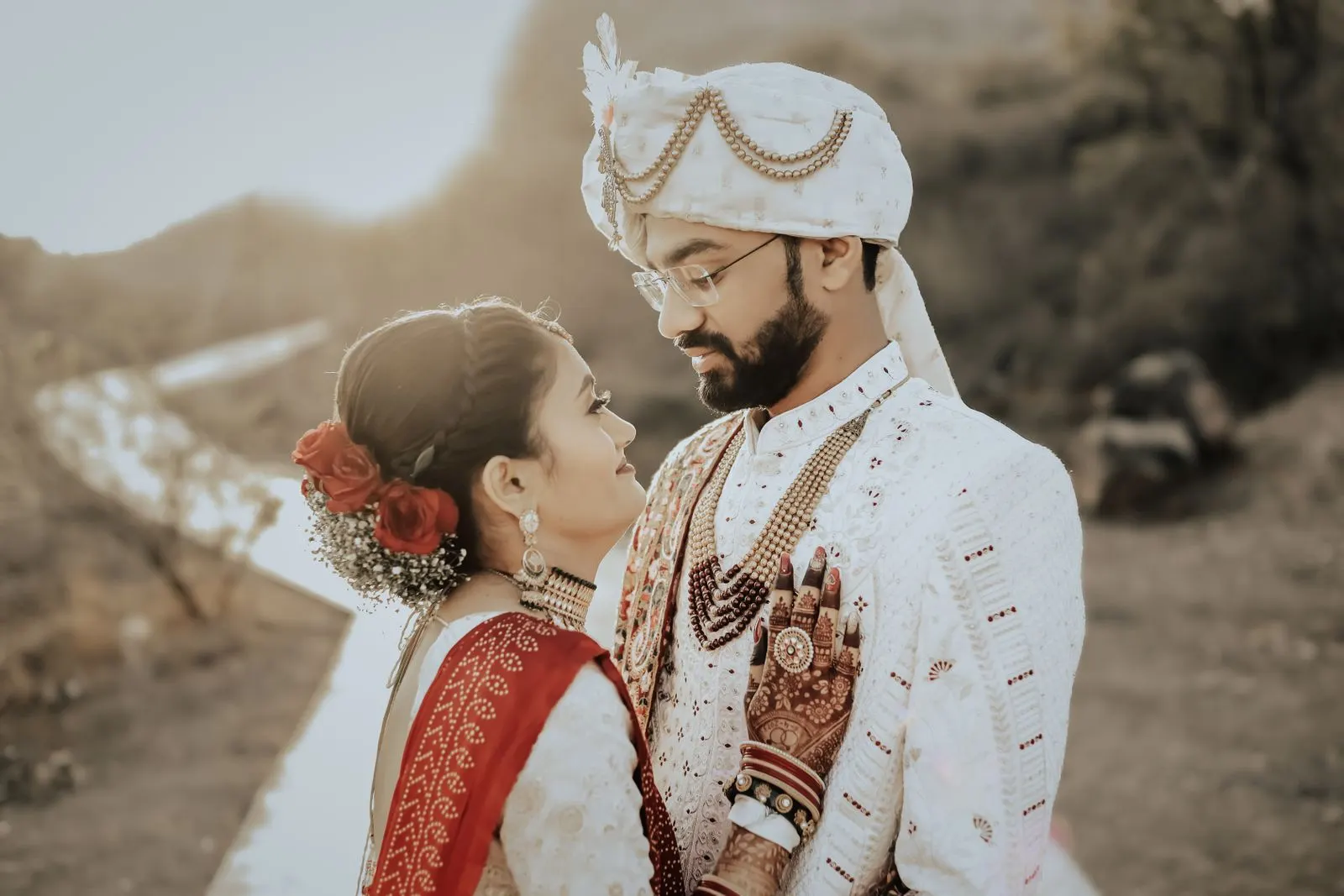A traditional Indian bride and groom in a golden-hour embrace